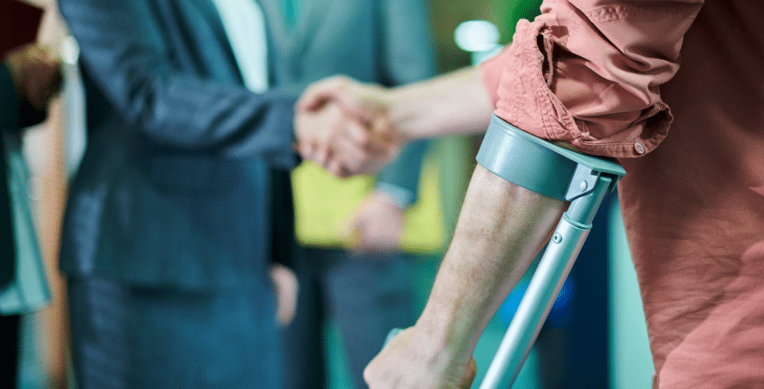 a client using crutch shaking hands with a lady