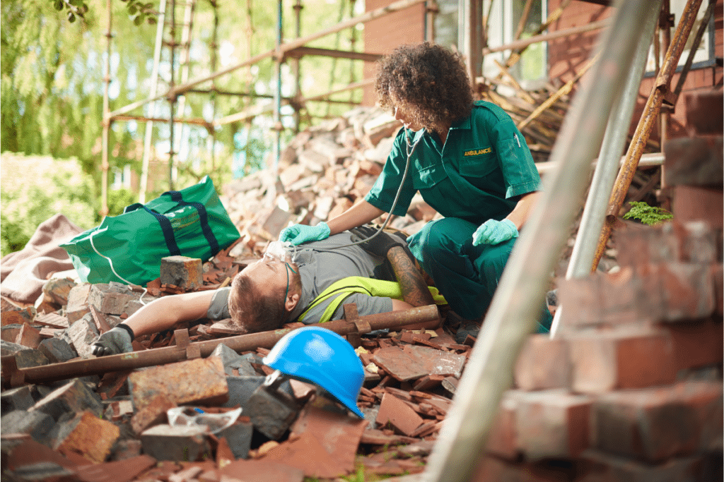 a person in green uniform helping a person on the ground