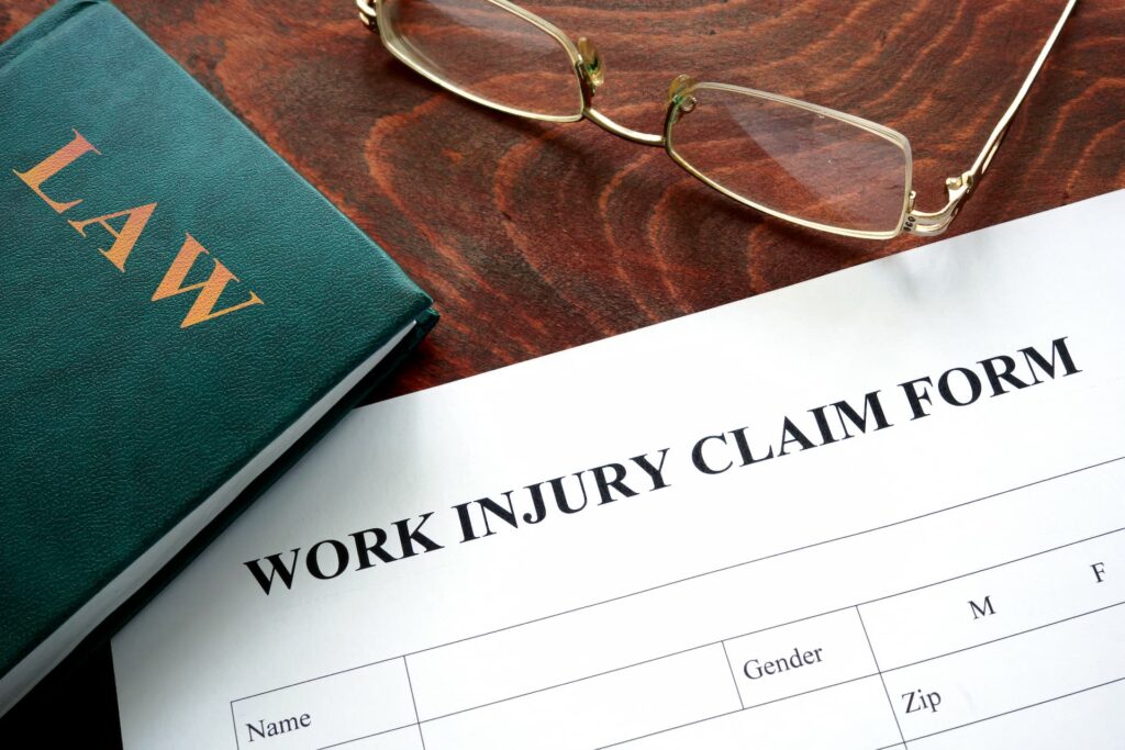 a work injury claim form and glasses on a table