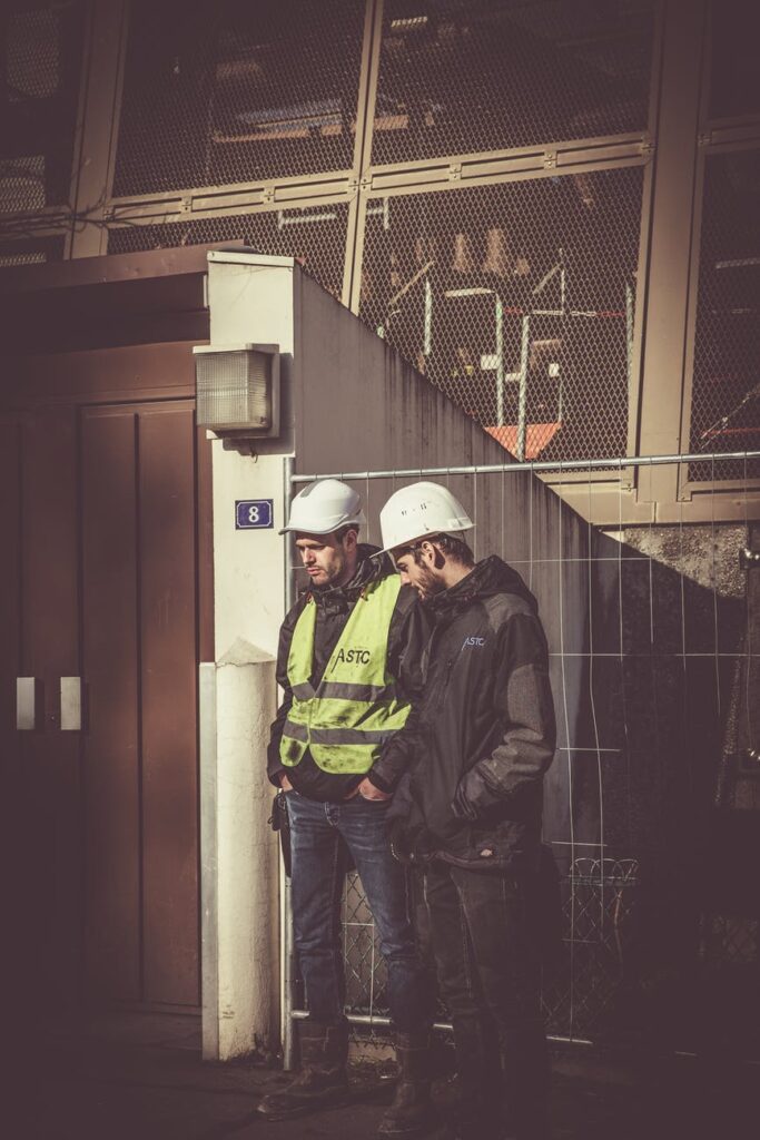 two men wearing hard hats and vests