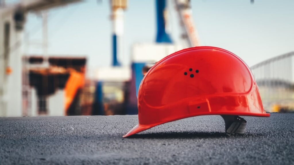 a red hard hat on a concrete surface