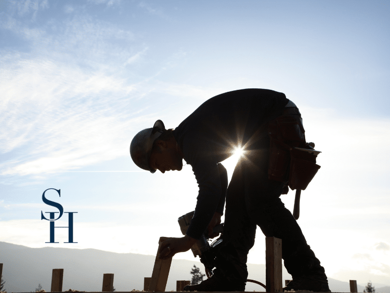 silhouette of a construction worker on a roof