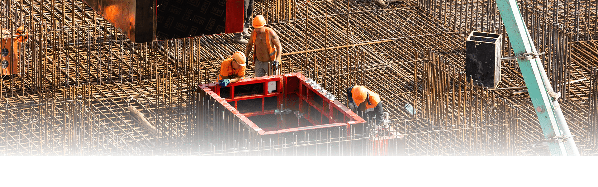 Trabajadores trabajando con hierros de concreto en un sitio de construcción.