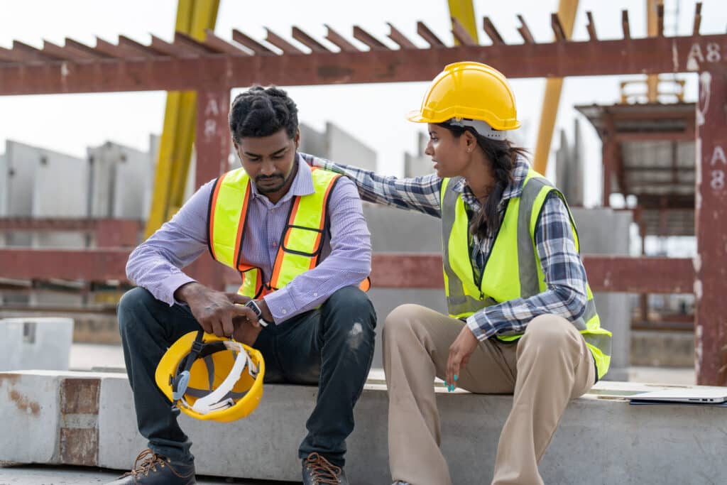 Female construction worker comforting a male colleague