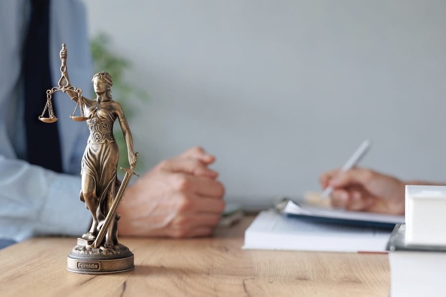 table with scales of justice and paperwork
