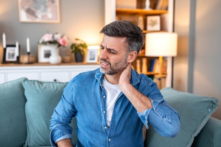An injured man holds his neck and worries about what happens if his boss says he was hurt off the clock.